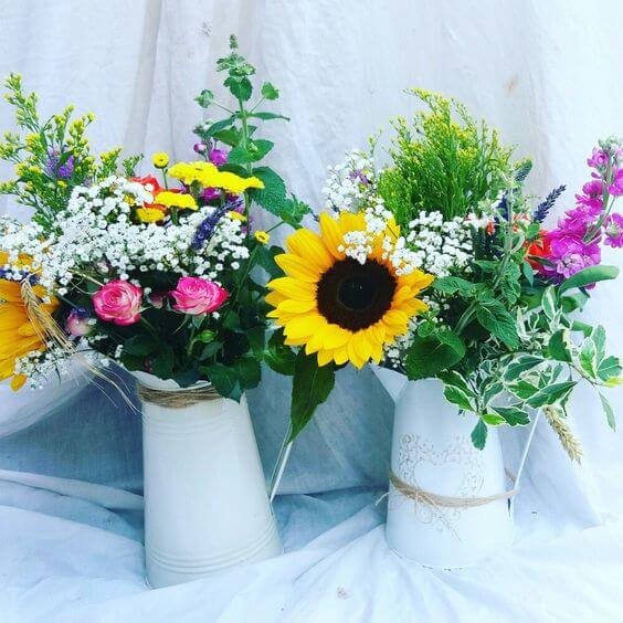 Sunflowers in milk jugs, mixed country wedding flower arrangement